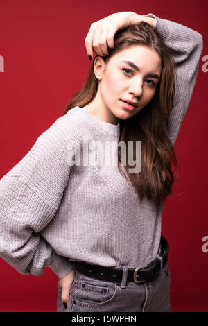 Attractive woman in sweater possing isolated on red background Stock Photo