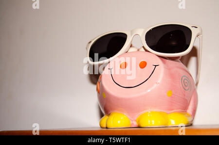 Close up of pink piggy bank with sun glasses Stock Photo