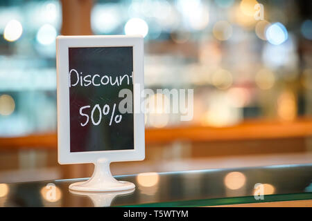 discount 50% on the black board standy in the bakery shop. Beautiful Blurry and bokeh background Stock Photo