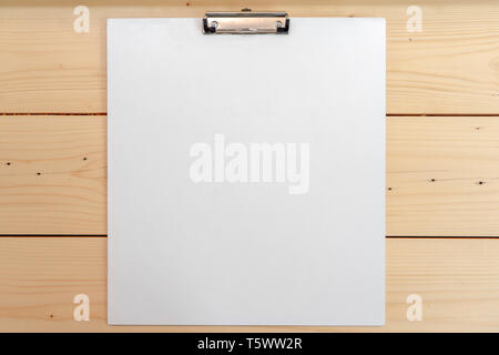white empty plastic clipboard lay on the wood table. Stock Photo