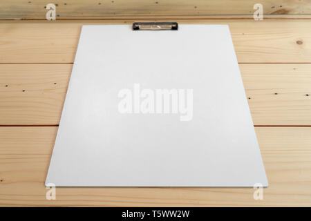 white empty plastic clipboard lay on the wood table. Stock Photo