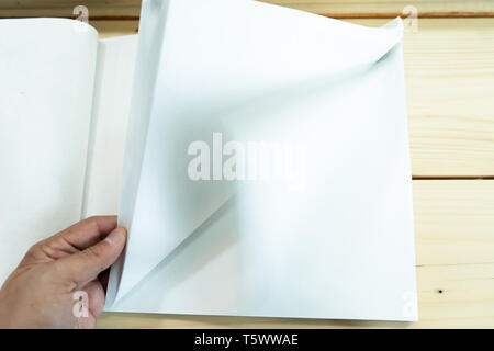 man hand open the white empty notebook on the wood table. Stock Photo