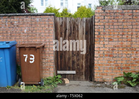 shabby wooden gate with brick wall Stock Photo