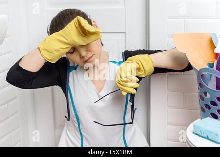 Tired adult woman cleaning bathroom toilet room Stock Photo