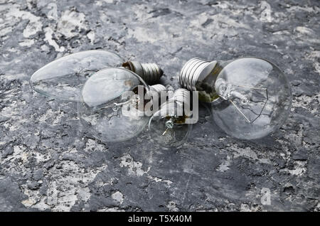 Many different types of incandescent bulbs on a gray concrete background. The interior is loft style. Stock Photo