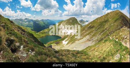 panorama of fagaras mountain in summer. glacier lake capra between hills. beautiful landscape with steep slopes, grassy meadows and peak. wonderful we Stock Photo