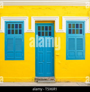 Blue door and windows on yellow wall, property and real estate concept Stock Photo
