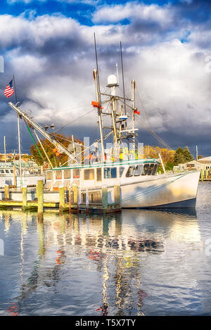 A variety of different boats docked in the inner harbor on Lewis Bay in Hyannis Massachusetts against a stormy sky in new england. Stock Photo