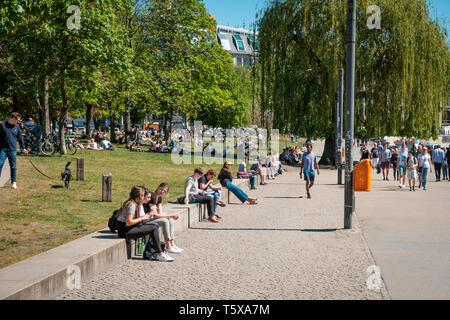 Berlin, Germany - April, 2019: People sitting outdoor on street and in public park on a summer day in Berlin Stock Photo