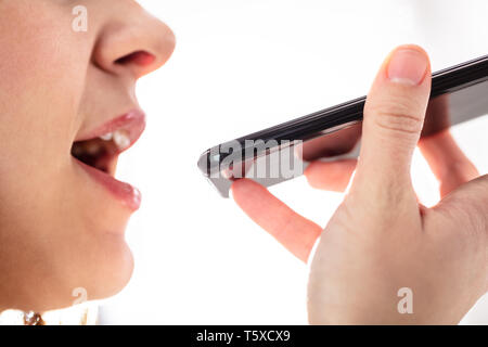Close-up Of Young Woman Using Voice Assistant On Cellphone Stock Photo