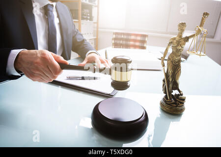 Mallet And Sounding Block With Statue Of Justice In Front Of Judge At Court Stock Photo