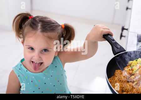 Smiling Small Pretty Girl Girl Playing With Hot  Cooking Pan In Kitchen Stock Photo
