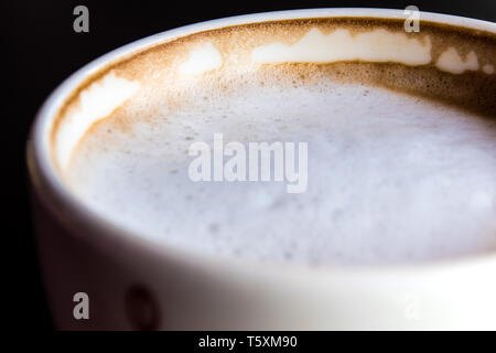 Stain of Hot milk coffee and soft froth inside the white ceramic cup Stock Photo