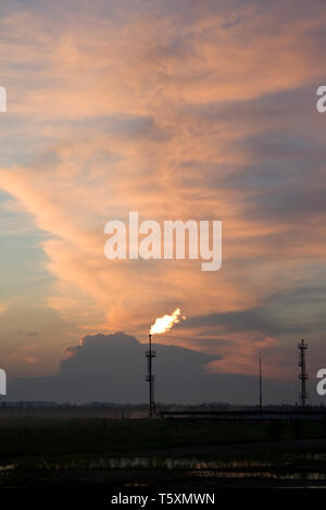 silhouette of oil refinery tower with flame at sunset Stock Photo - Alamy