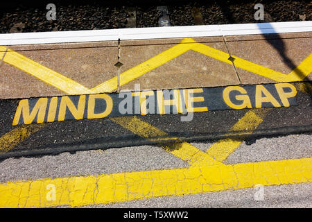 'Mind the gap' warning sign on the railway platform edge. Stock Photo