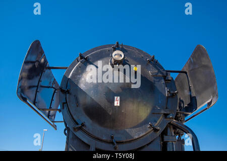 old locomotive with coal running from the front against blue sky Stock Photo