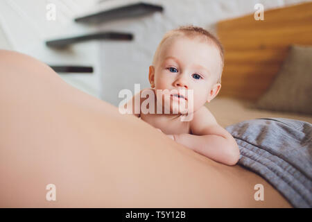 Happy father with baby lying on bed at home. Stock Photo