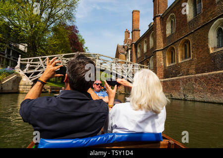 Tourist couple in a punt taking photos of the Mathematical Bridge over the River Cam, University town of Cambridge, Cambridgeshire, England Stock Photo