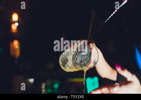 female bartender. girl with blue hair. cocktail making in night bar. Stock Photo