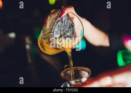 female bartender. girl with blue hair. cocktail making in night bar. Stock Photo