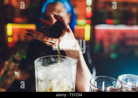 female bartender. girl with blue hair. cocktail making in night bar. Stock Photo