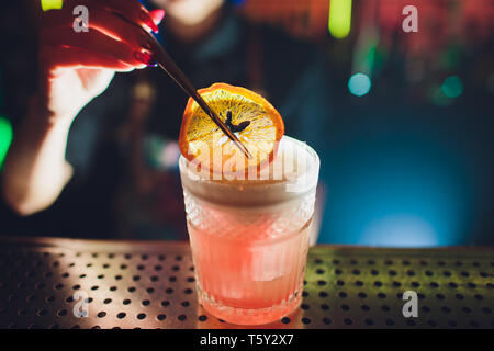 female bartender. girl with blue hair. cocktail making in night bar. Stock Photo