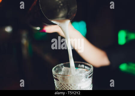 female bartender. girl with blue hair. cocktail making in night bar. Stock Photo