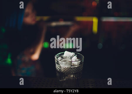 female bartender. girl with blue hair. cocktail making in night bar. Stock Photo