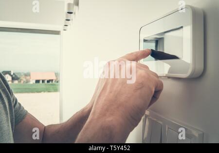 Home Climate Controlling Using Wall Control Device. Air Conditioning and Heating in a House. Touch Panel. Stock Photo