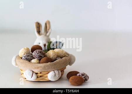 Different Easter Chocolate almond eggs on bunny basket Stock Photo