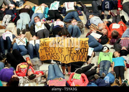 Glasgow, Scotland, UK 27th April, 2019. Kelvingrove Art Galleries and Museum saw a copycat protest at climate change to the blue whale in London as dippy the Diplodocus saw an Extinction Rebellion Climate change protesters lie down protest ie “die- in” through earth being poisoned. Gerard Ferry/Alamy Live News Stock Photo