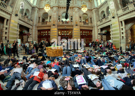 Glasgow, Scotland, UK 27th April, 2019. Kelvingrove Art Galleries and Museum saw a copycat protest at climate change to the blue whale in London as dippy the Diplodocus saw an Extinction Rebellion Climate change protesters lie down protest ie “die- in” through earth being poisoned. Gerard Ferry/Alamy Live News Stock Photo