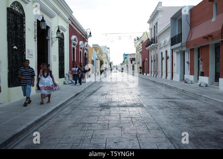 Merida, Yucatan, Mexico - 2019: View of a typical cobblestone street near the city center, with local people walking on the sidewalk. Stock Photo