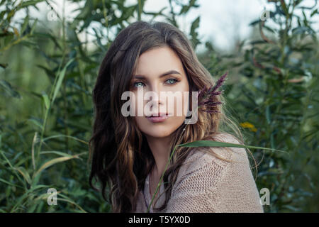 Cute young woman relaxing in summer grass Stock Photo