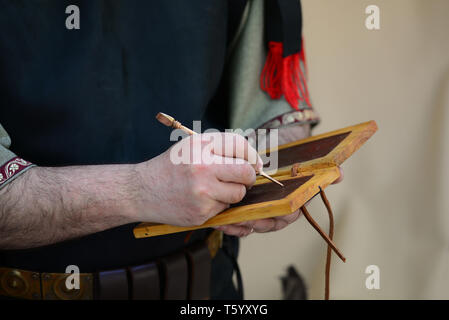 Roman empire soldier writing on wax tablet detail Stock Photo