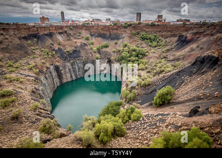 Wide view of The Big Hole in Kimberley, a result of the mining industry, with the town skyline on the edge Stock Photo