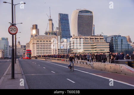 City of London, London, UK - February 8, 2018. Crowds of commuters during rush hour walk across London Bridge away from the City of London on their wa Stock Photo