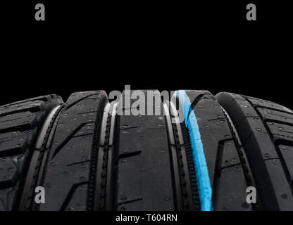 Studio shot of a set of summer car tires on black background. Tire stack background. Selective focus. Car tyre protector close up. Black rubber tire.  Stock Photo