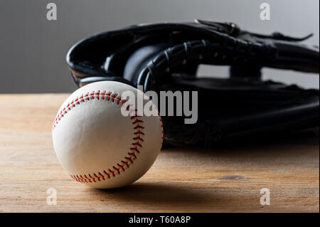 chocolate baseballs with baseball glove in background on wood board, sport concept Stock Photo