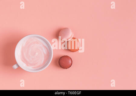 Cup of coffee with macaroons on pastel background, flat lay. Stock Photo