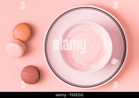 Cup of coffee with macaroons on pastel background, flat lay. Stock Photo