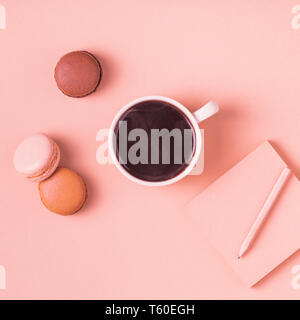 Cup of coffee with macaroons on pastel background, flat lay. Stock Photo