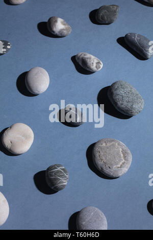 beautiful stones lying next to eath othe isolated on the blue background, top view Stock Photo