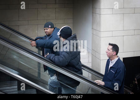 New York City, NY - March 07, 2017: Two unidentified man going up the escalator and talking in Penn Station, Manhattan, NY Stock Photo