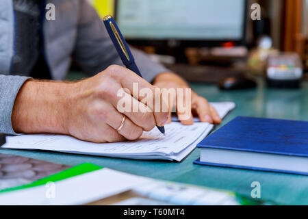 Person completing man hand with pen and business of application form signing business document Stock Photo