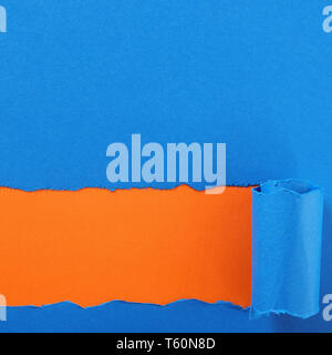 Torn blue paper strip orange background Stock Photo