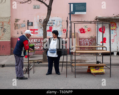 Cordoba City, Cordoba, Argentina - 2019: People prepare stands for a traditional flee market on the streets of the Guemes district. Stock Photo