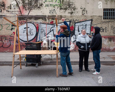 Cordoba City, Cordoba, Argentina - 2019: People prepare stands for a traditional flee market on the streets of the Guemes district. Stock Photo