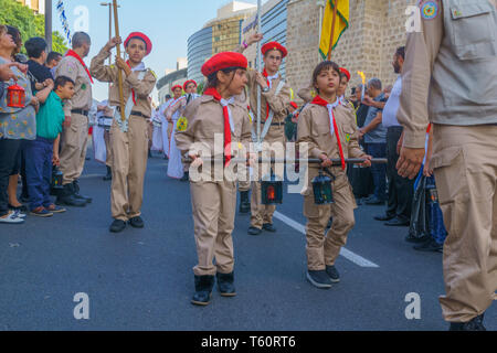 Haifa, Israel - April 27, 2019: Scouts perform a Holy Saturday parade, carrying the holy fire, and crowd attend and document, part of Orthodox Easter  Stock Photo