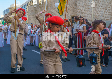 Haifa, Israel - April 27, 2019: Scouts perform a Holy Saturday parade, carrying the holy fire, and crowd attend and document, part of Orthodox Easter  Stock Photo